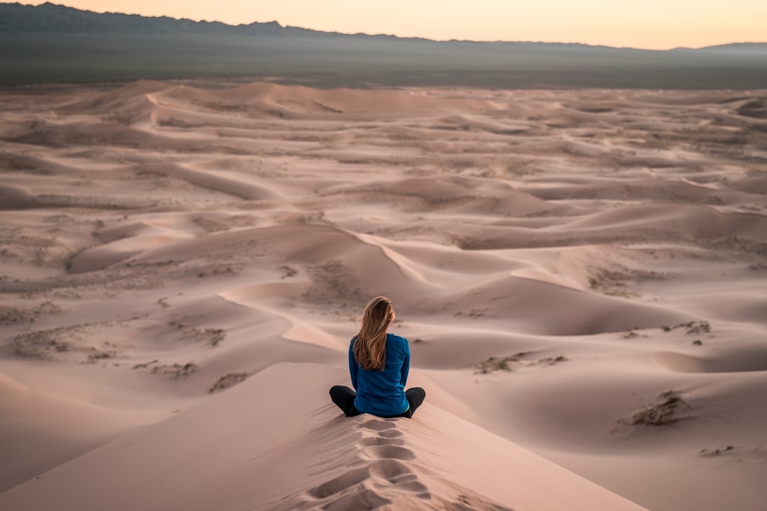 woman-sitting-on-sand-dunes