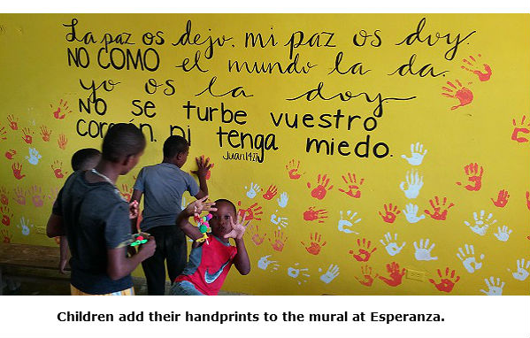 Children adding their handprints to the mural the TBC mission team painted in Esperanza