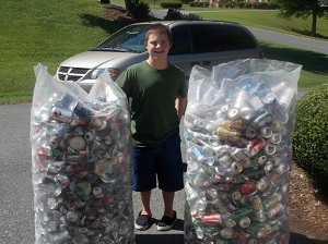 Justin Eaton with two large bags full of collected cans