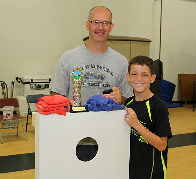 Jon and Adam Gordy with cornhole trophy and prize