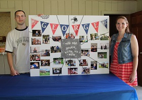 Will and Erika Gibson with poster celebrating the addition of George to their family