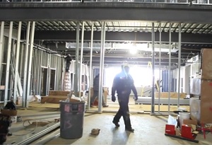 Construction worker walks through Worship Center/Gym site